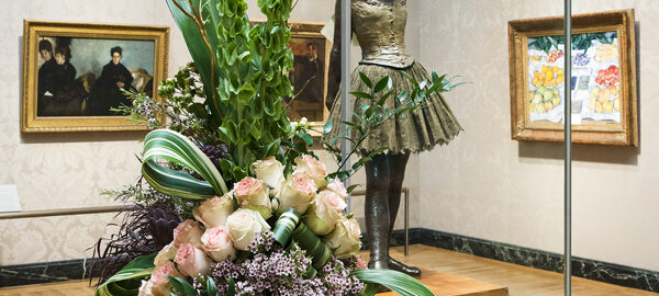 A spectacular floral arrangement compliments the Edgar Degas sculpture “The Little Fourteen-Year-Old Dancer” during a past Art in Bloom celebration at the Boston MFA. (Photo courtesy of the MFA)